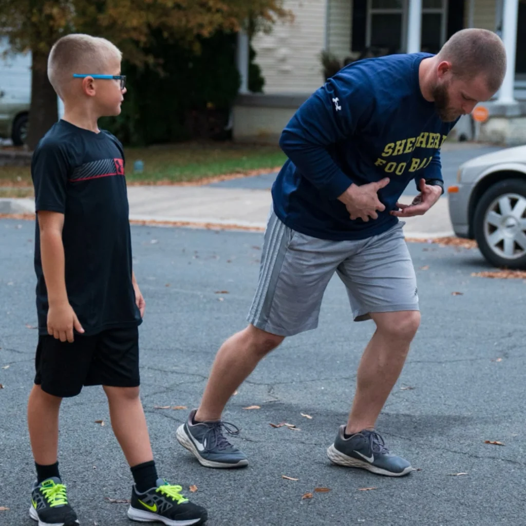 Coach demonstrating proper sprinting form to athlete