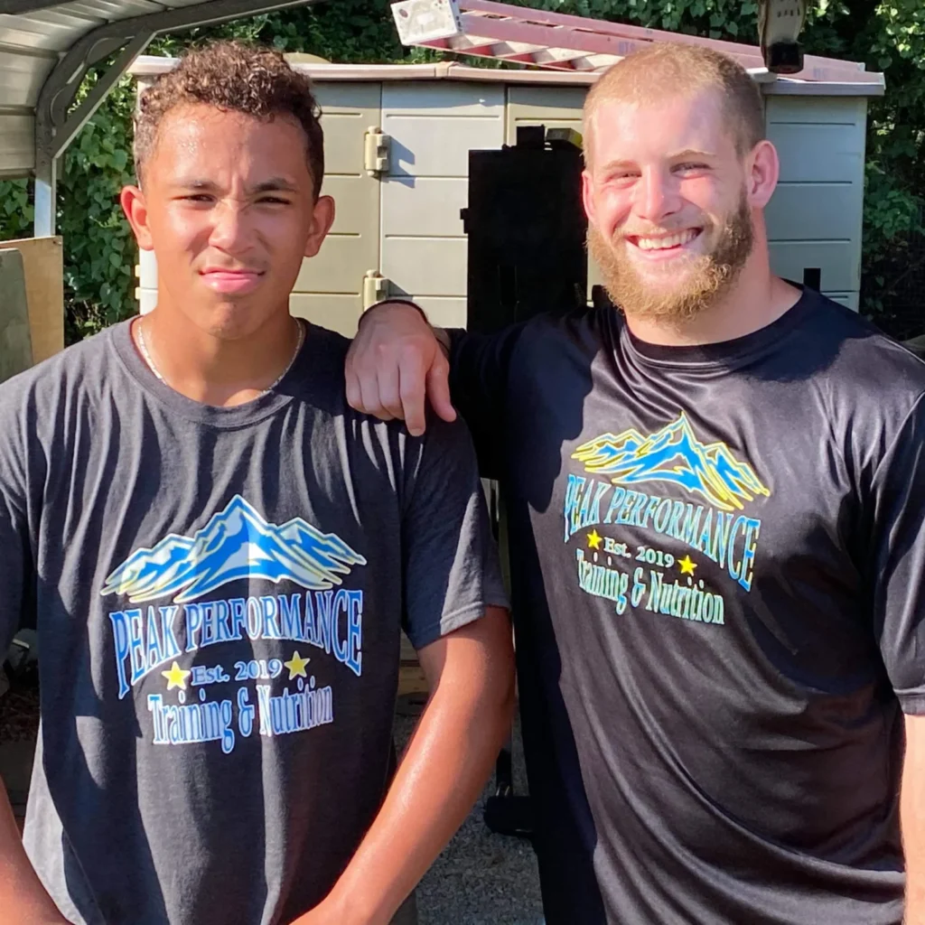 Coach and athlete with Peak Performance Training & Nutrition shirts on