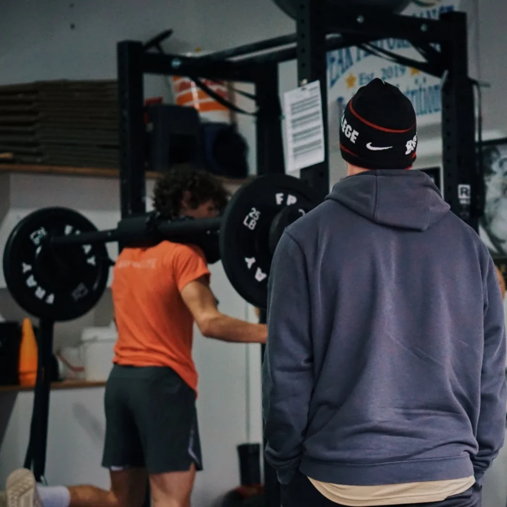 Coach taking athlete through athletic performance training workout