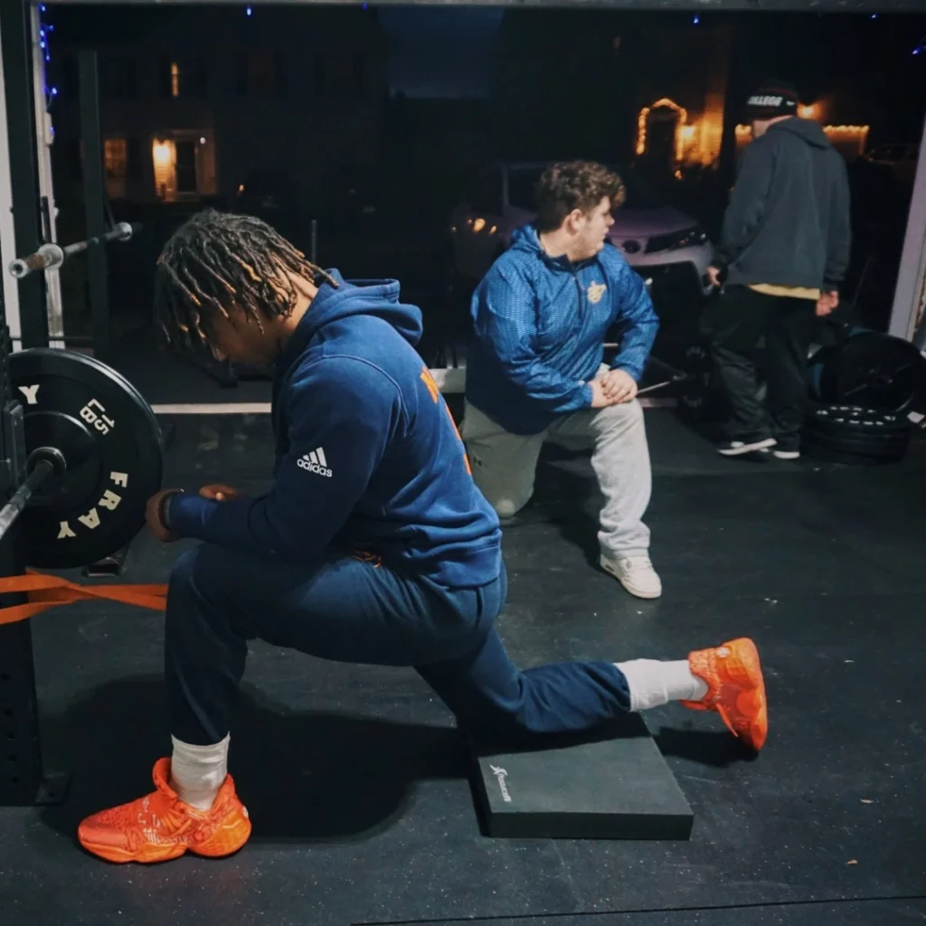 Athletes stretching legs in gym before workout