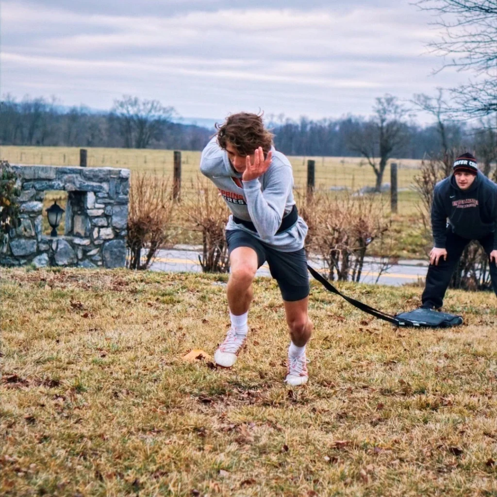 Peak Performance coach viewing athlete performing weighted sprints